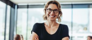 Nahaufnahme einer lächelnden Frau mit Brille - Praktische Prüfung - Symbolbild